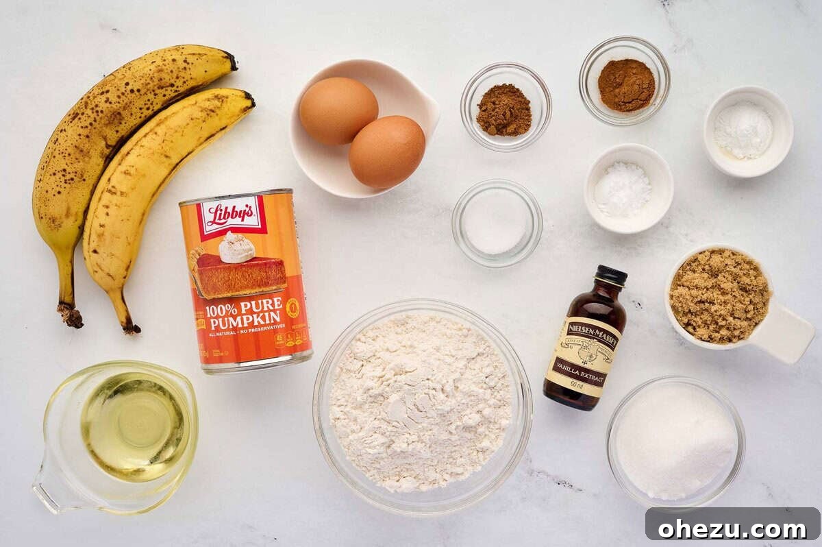 A vibrant collection of fresh and pantry ingredients for pumpkin banana bread neatly arranged on a kitchen counter