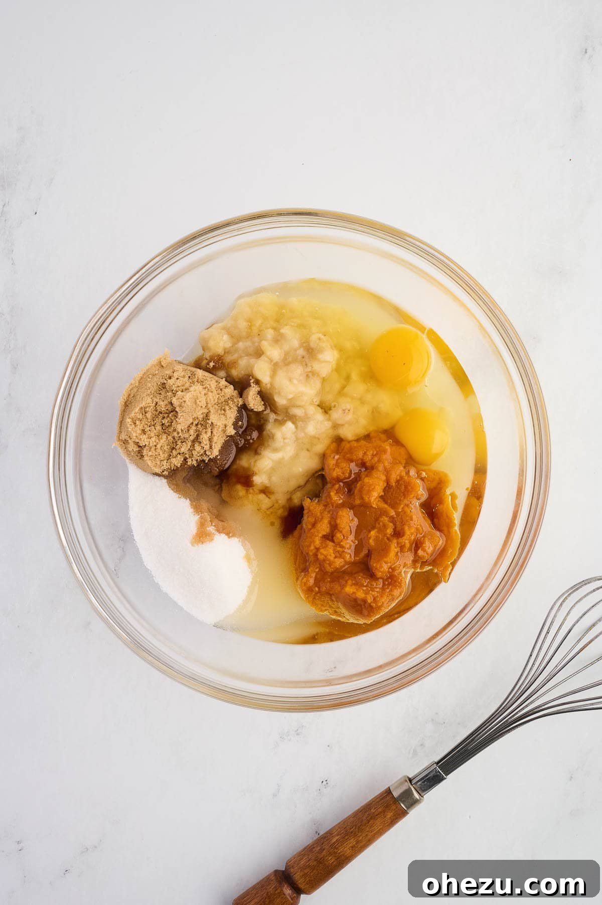 All wet ingredients, including mashed bananas, pumpkin puree, oil, eggs, sugars, and vanilla, thoughtfully placed in a mixing bowl