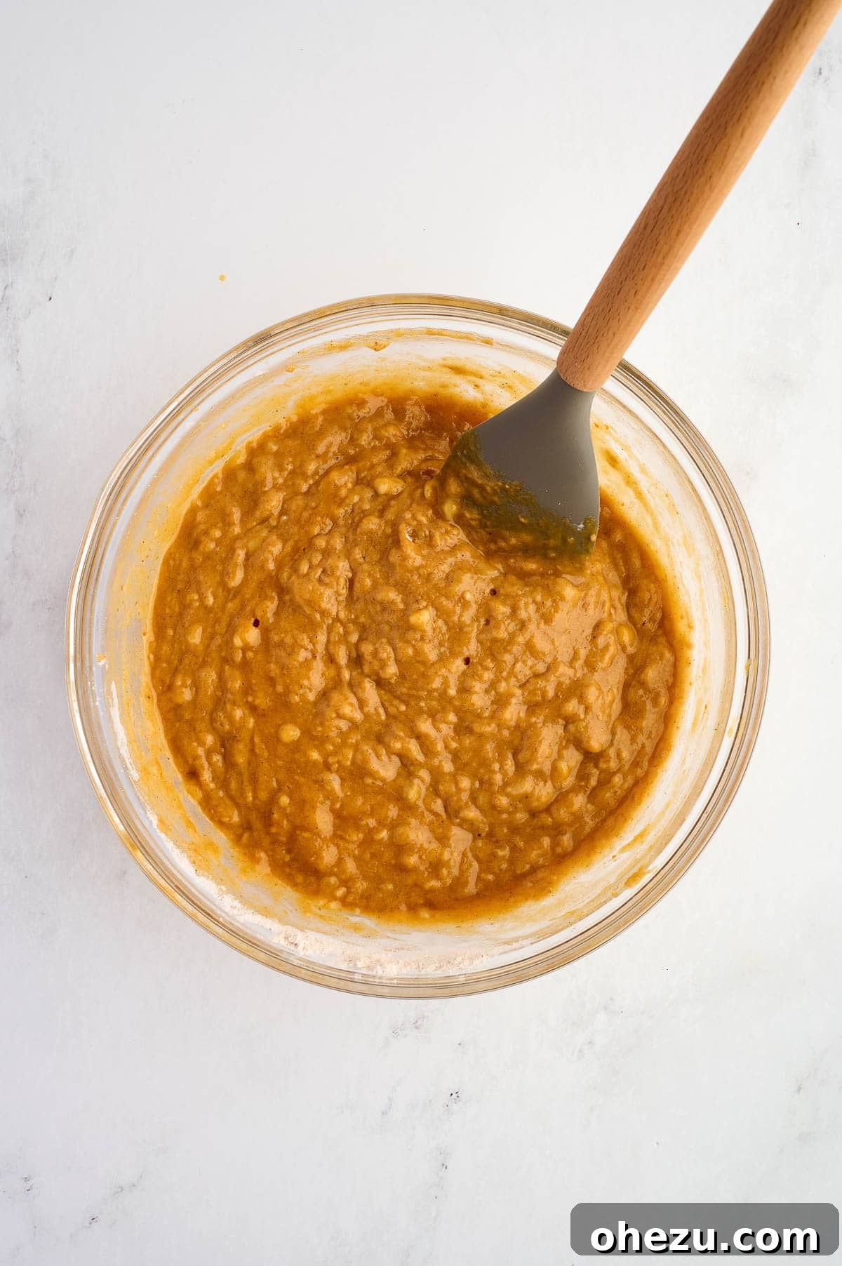 Pumpkin banana bread batter, perfectly mixed to a slightly lumpy consistency with no dry streaks visible, indicating careful preparation