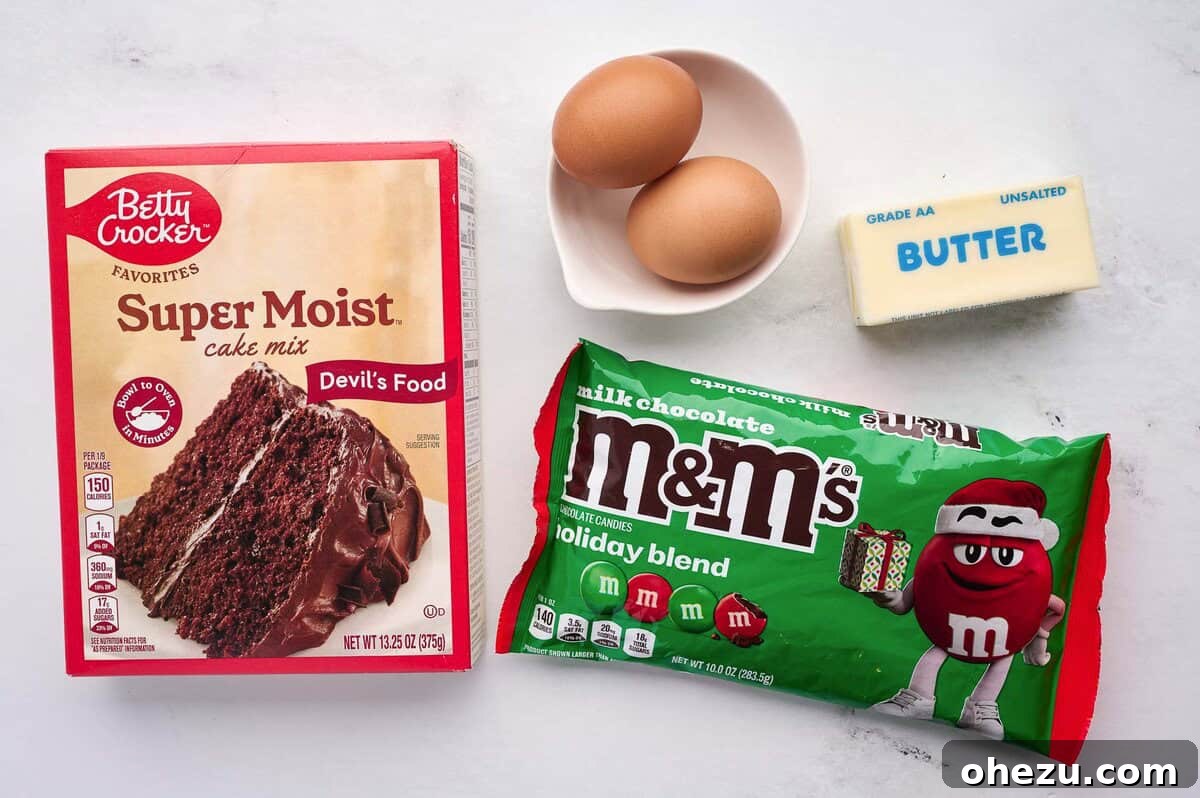 ingredients laid out: chocolate cake mix, M&M's, eggs, and butter