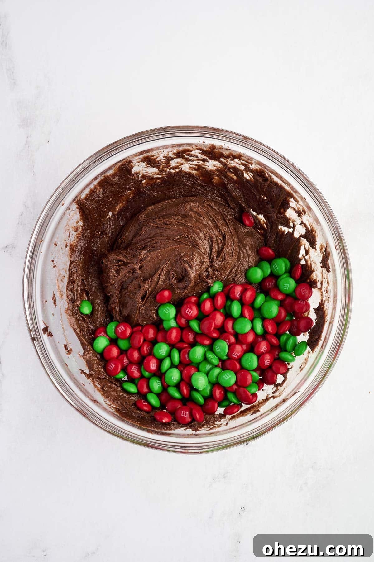 adding Christmas M&M's to the chocolate cookie batter
