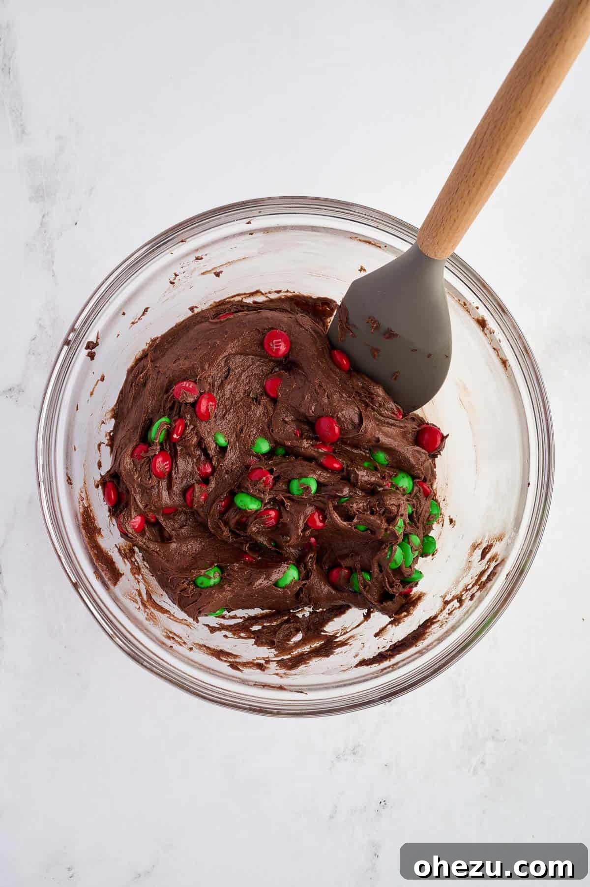 chocolate Christmas cookie batter mixed with M&M's in a bowl