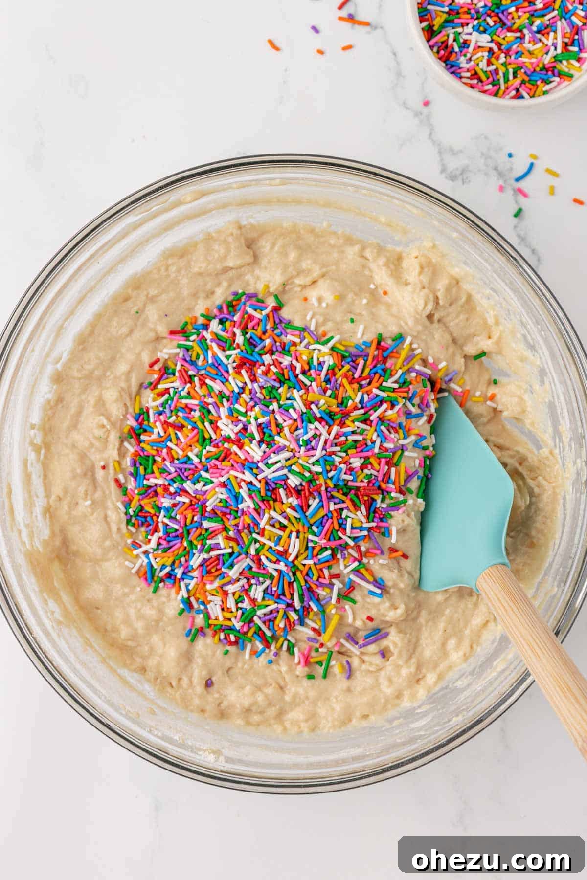 Folding colorful sprinkles into the muffin batter