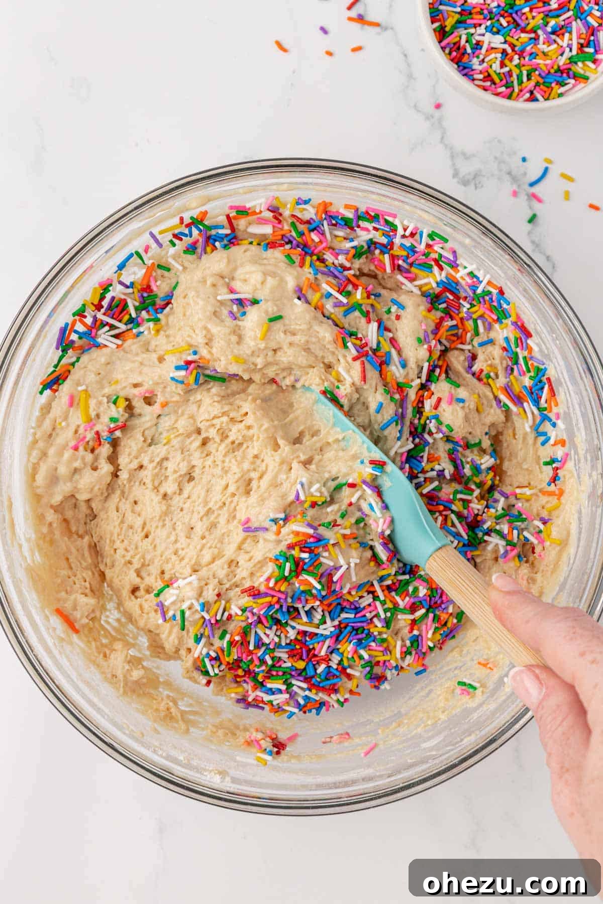 Muffin batter with sprinkles gently folded in, ready for baking