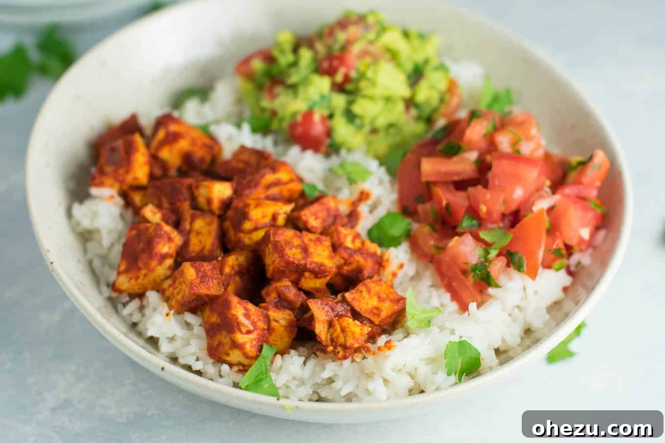 Quick Fiesta Tofu Burrito Bowls 3 Close-up view of a colorful and hearty enchilada tofu burrito bowl, showcasing the textures of the ingredients.