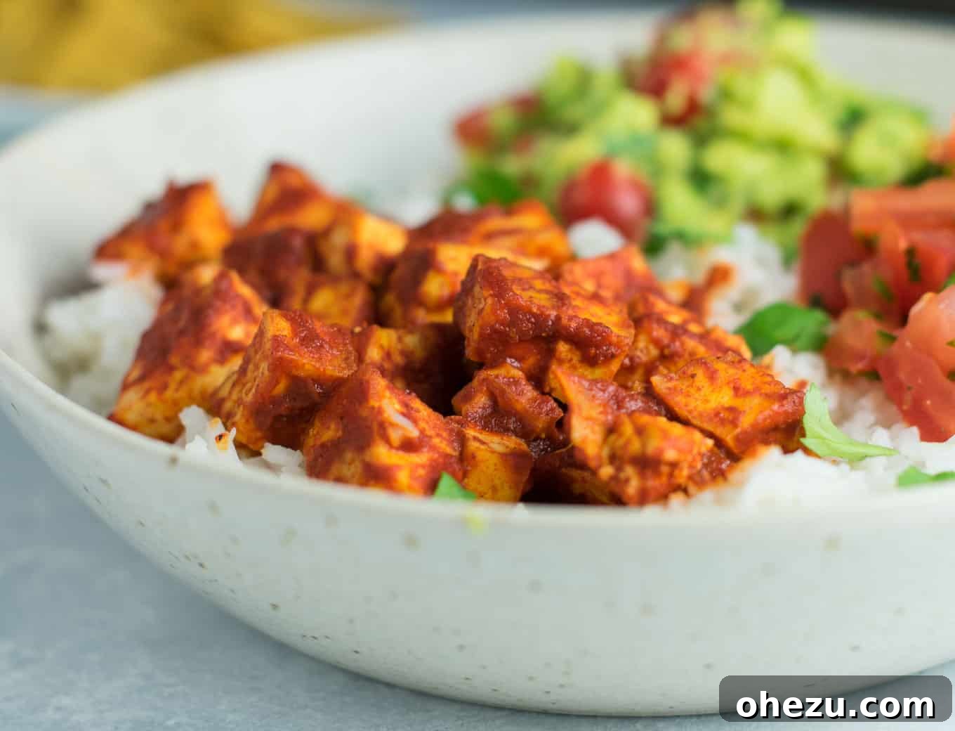 Quick Fiesta Tofu Burrito Bowls 4 Diced extra-firm tofu ready for baking on parchment paper, illustrating the moisture-removal step.