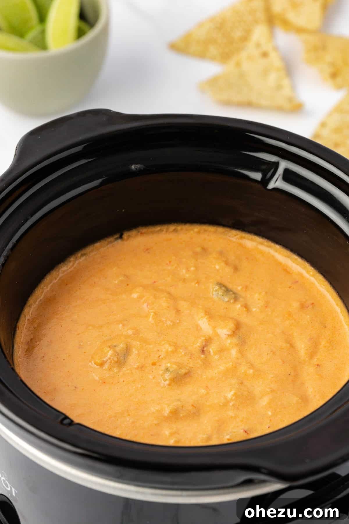 A close-up of creamy crock pot queso dip, showing its rich, melted cheese texture without velveeta, ready for dipping.