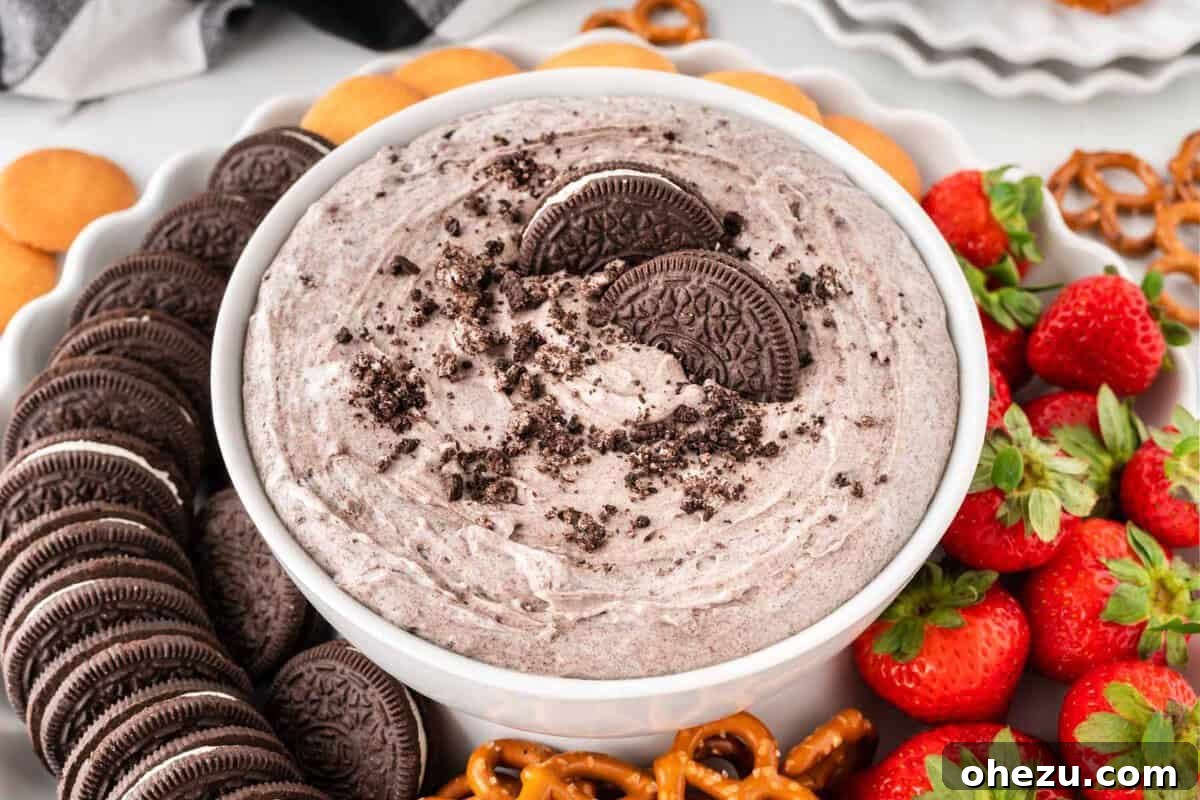 A bowl of creamy Oreo dip, perfect for a New Year's Eve dessert, surrounded by an assortment of dippers like cookies and fruit.