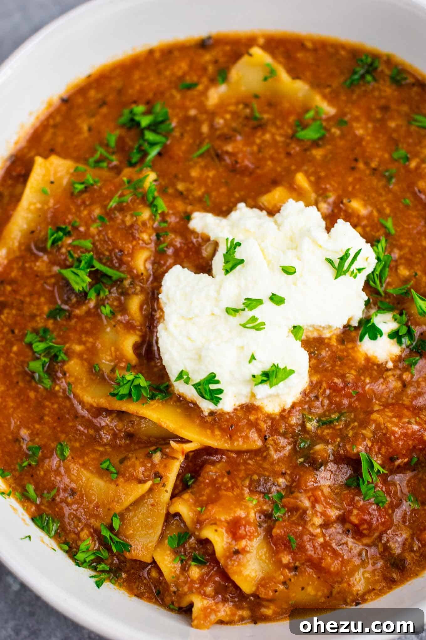 Delicious one-pot vegetarian lasagna soup served in a bowl, garnished with ricotta and fresh parsley. A perfect quick and healthy meatless dinner recipe.