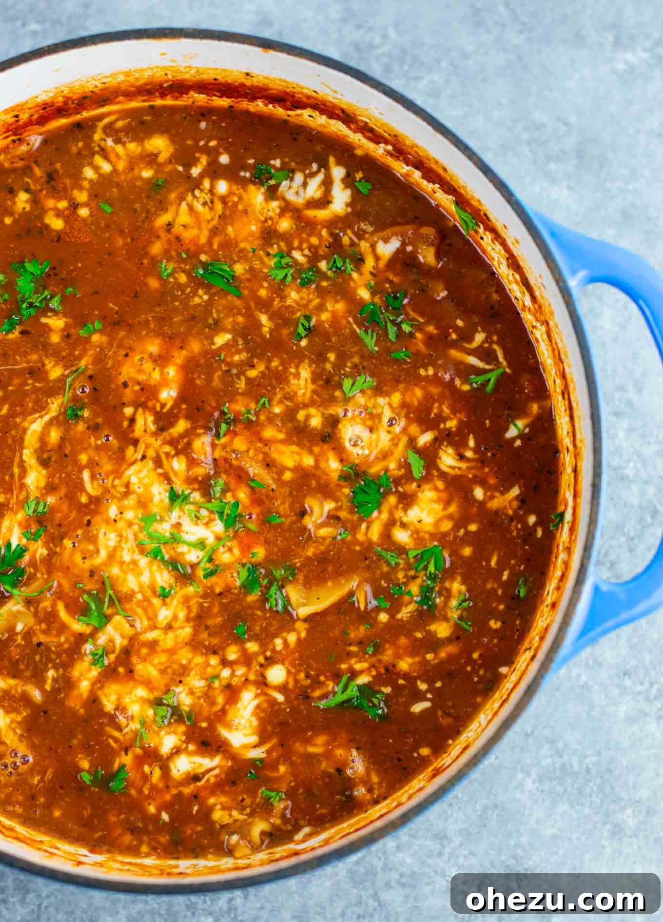 Hearty one-pot vegetarian lasagna soup in a large pot, with melted mozzarella cheese stirred in, ready to be served.