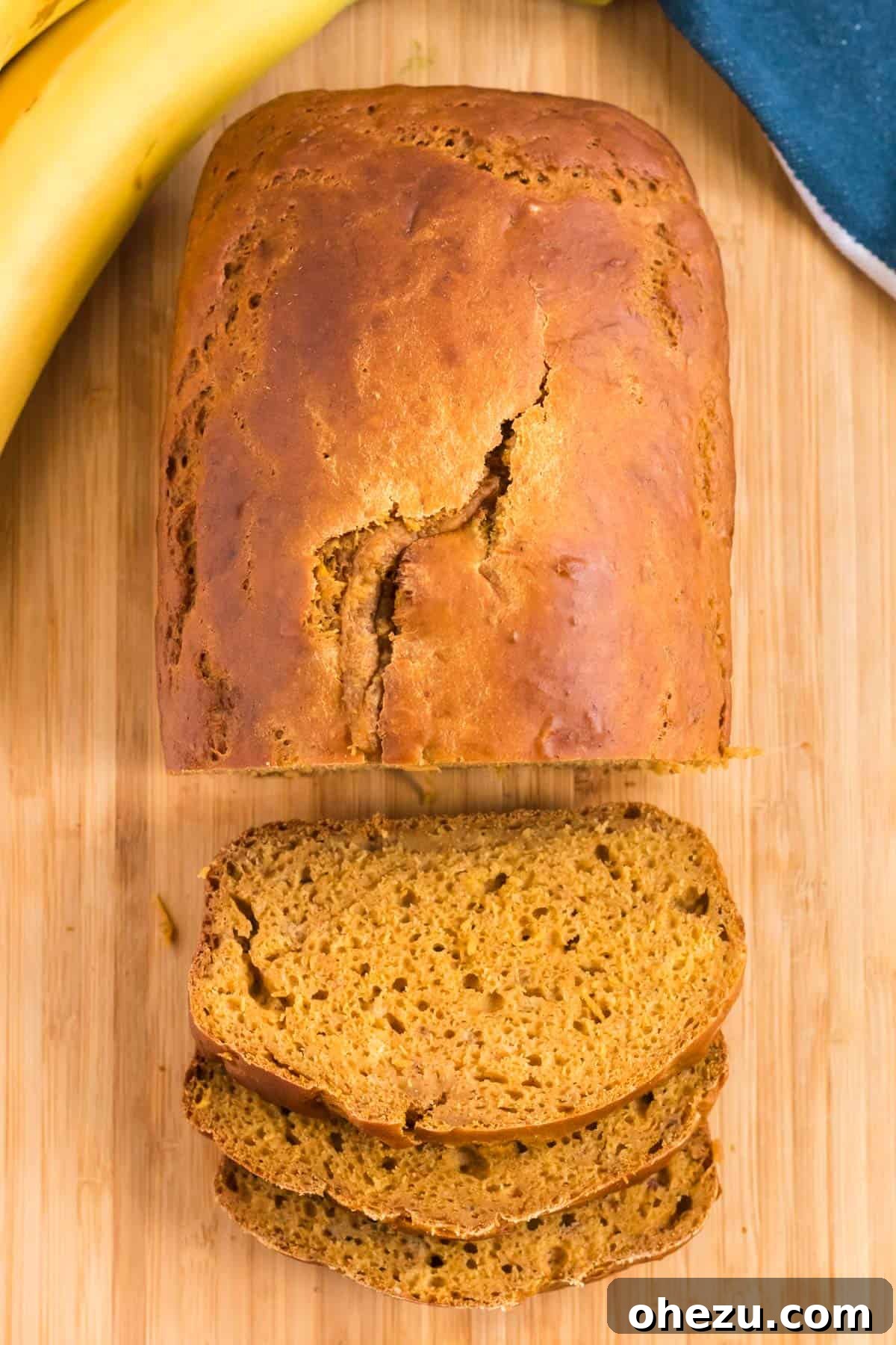 A close-up of healthy pumpkin banana bread being sliced, focusing on the knife and the bread.