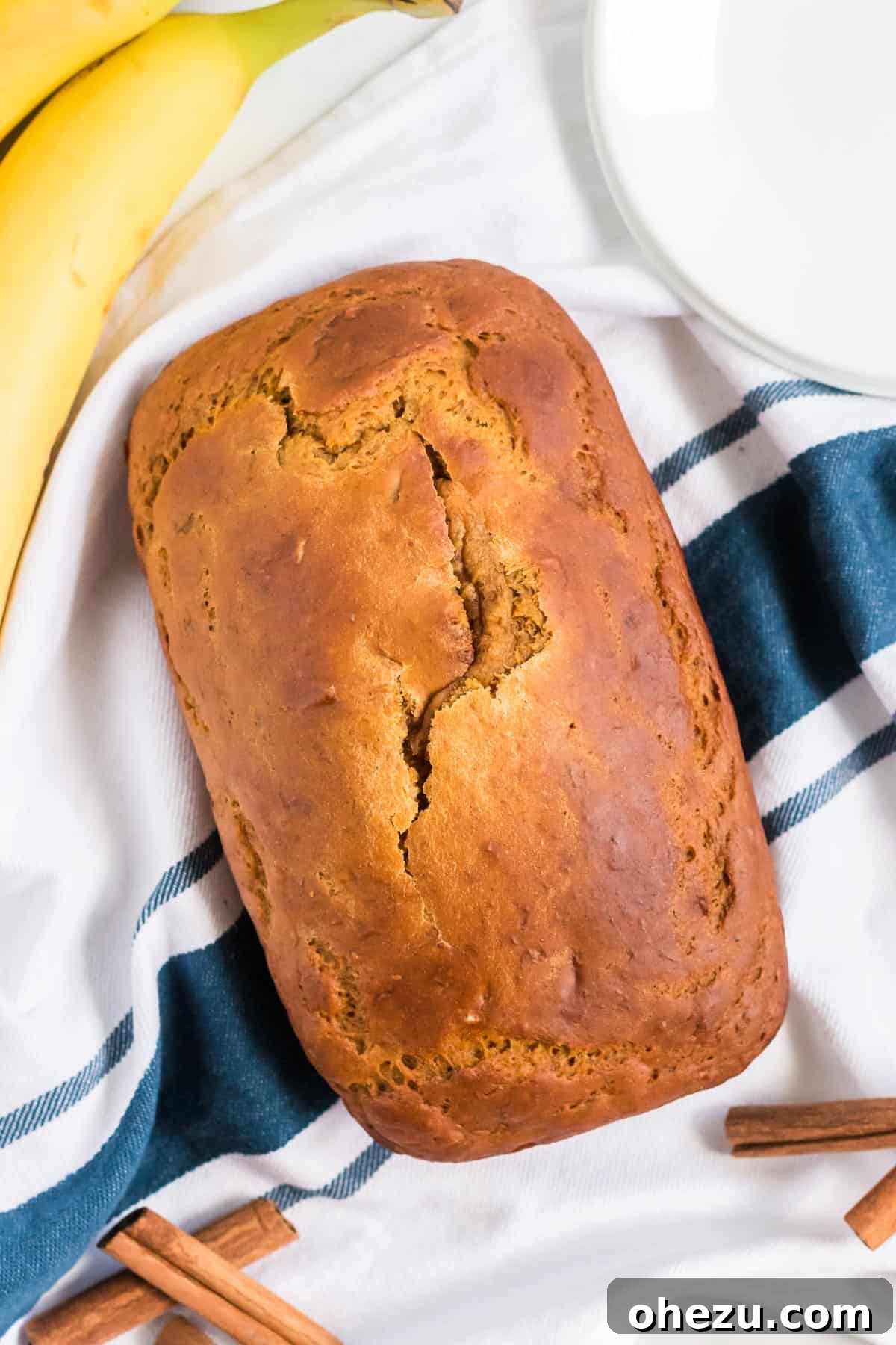 The full pumpkin loaf resting on a rustic kitchen towel, highlighting its wholesome, homemade appeal.