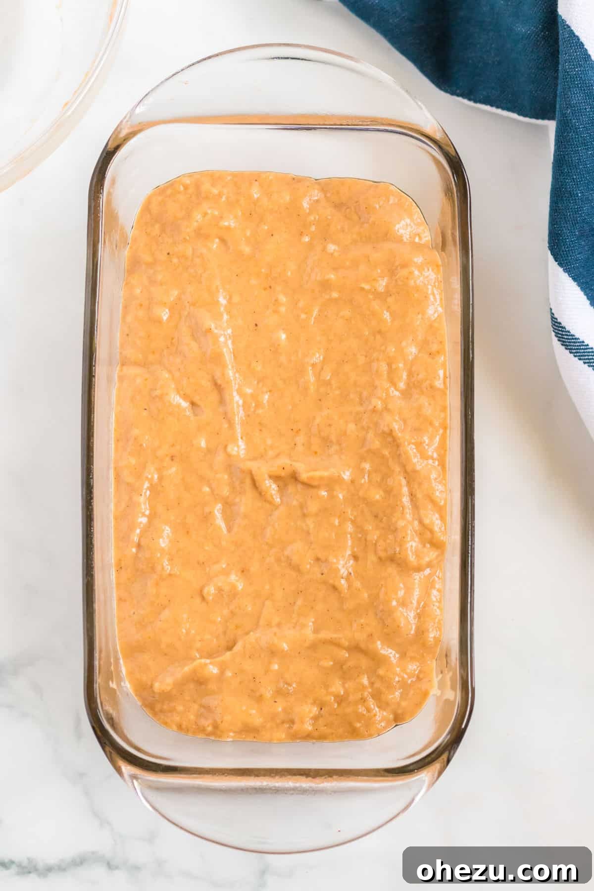 The smooth, fragrant pumpkin banana bread batter perfectly spread into a greased loaf pan, ready for baking.