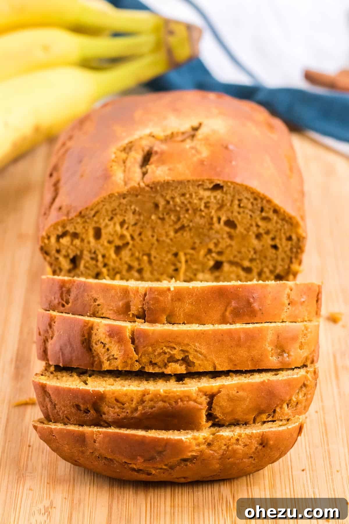 Another view of the healthy pumpkin banana bread being sliced, emphasizing its appealing texture.