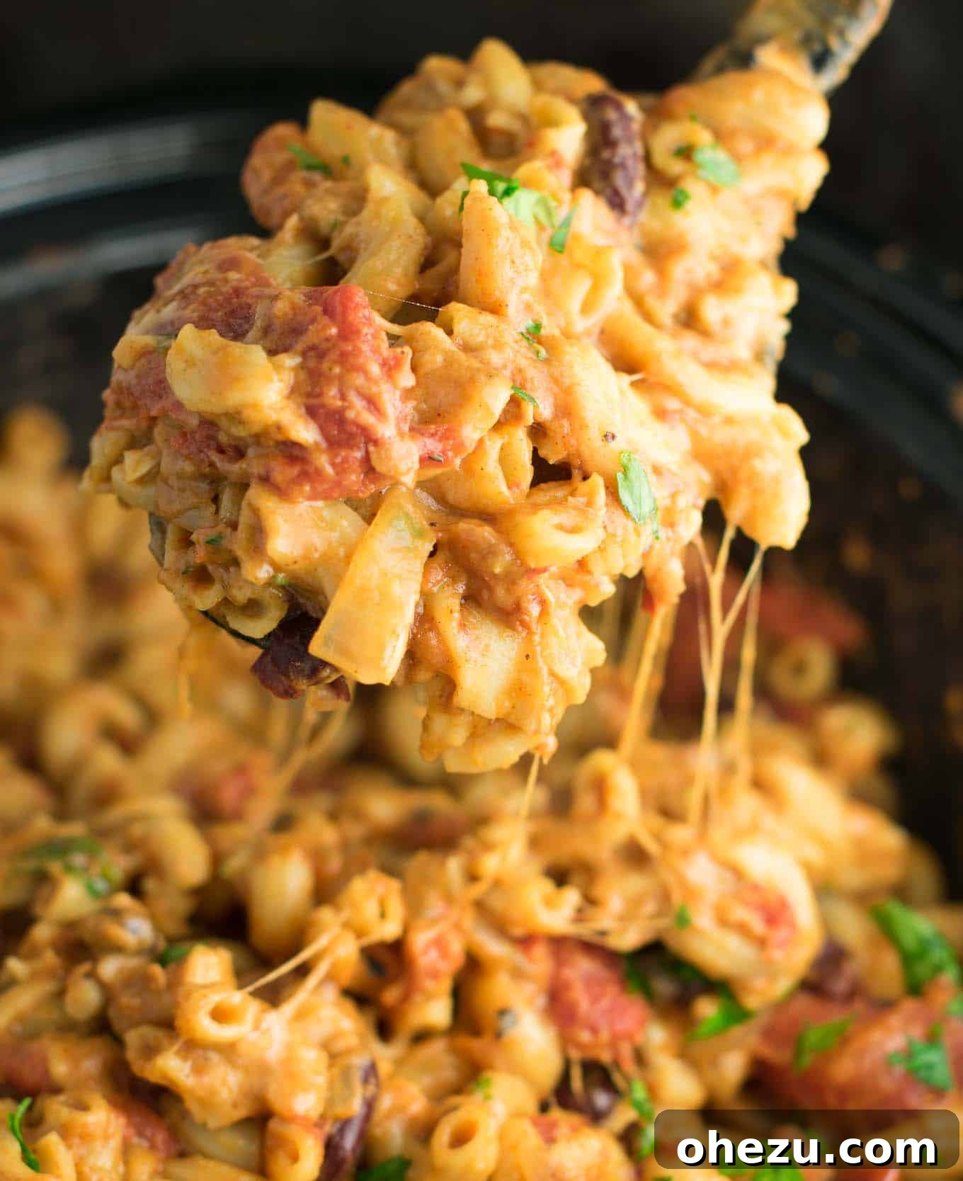 Easy vegetarian slow cooker chili with macaroni, showing fresh grated cheese