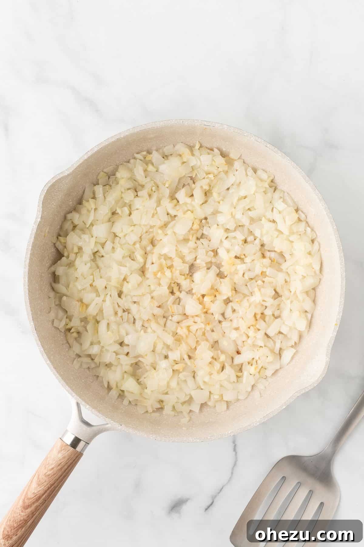 Cooked and softened onion and garlic in a skillet, ready for the next ingredients.