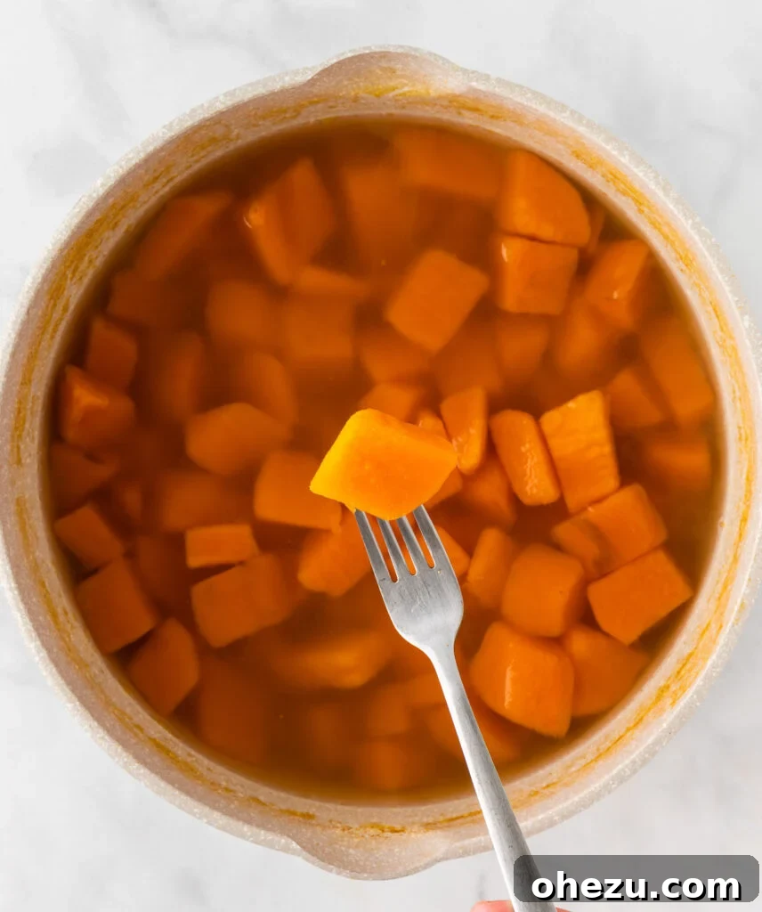 Golden Gluten-Free Sweet Potato Bake 6 Cooked sweet potato being tested with a fork for tenderness
