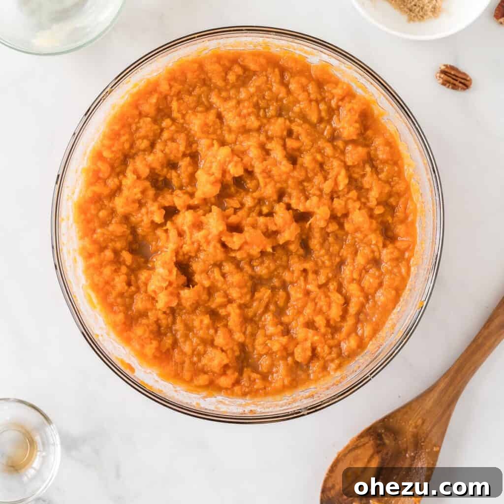 Golden Gluten-Free Sweet Potato Bake 8 The sweet potato casserole filling ingredients thoroughly mixed together in a bowl, creating a smooth mixture