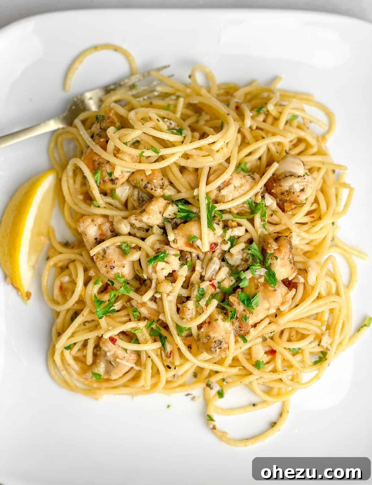 The Ultimate Homemade Chicken Scampi 4 Plated Chicken Scampi with pasta, lemon wedge, and fresh parsley garnish
