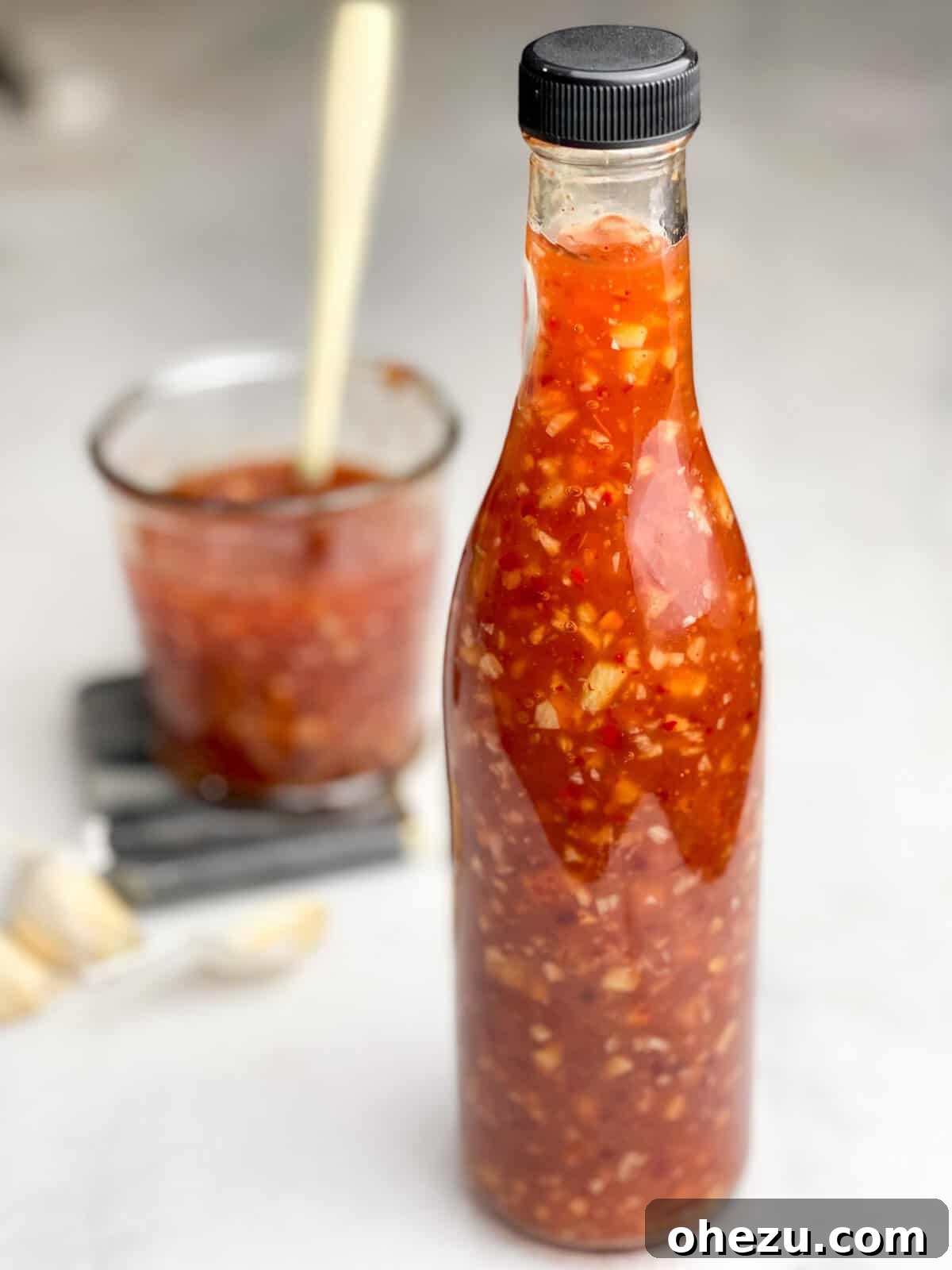 A collection of fresh ingredients for homemade sweet chili sauce, including garlic, ginger, and chilies