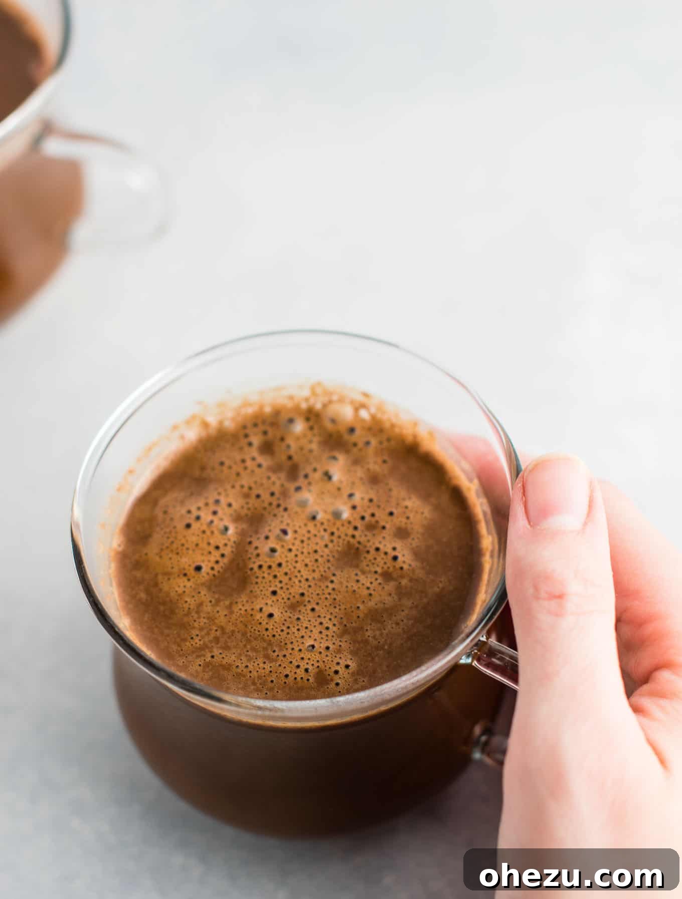 A close-up shot of vegan hot chocolate, with a perfectly melted, smooth and rich texture, emphasizing its appealing quality and deliciousness.
