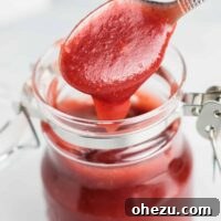 taking a spoonful of cranberry apple butter from a jar