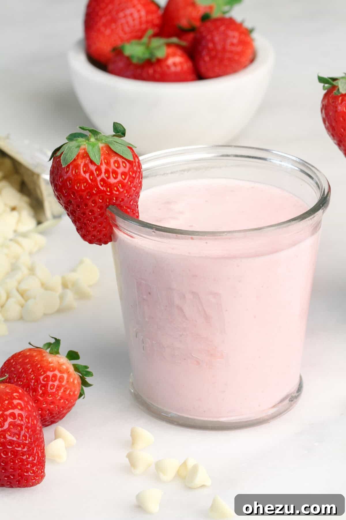 A vibrant Strawberry White Chocolate Smoothie, served in a tall glass with fresh strawberry garnish.