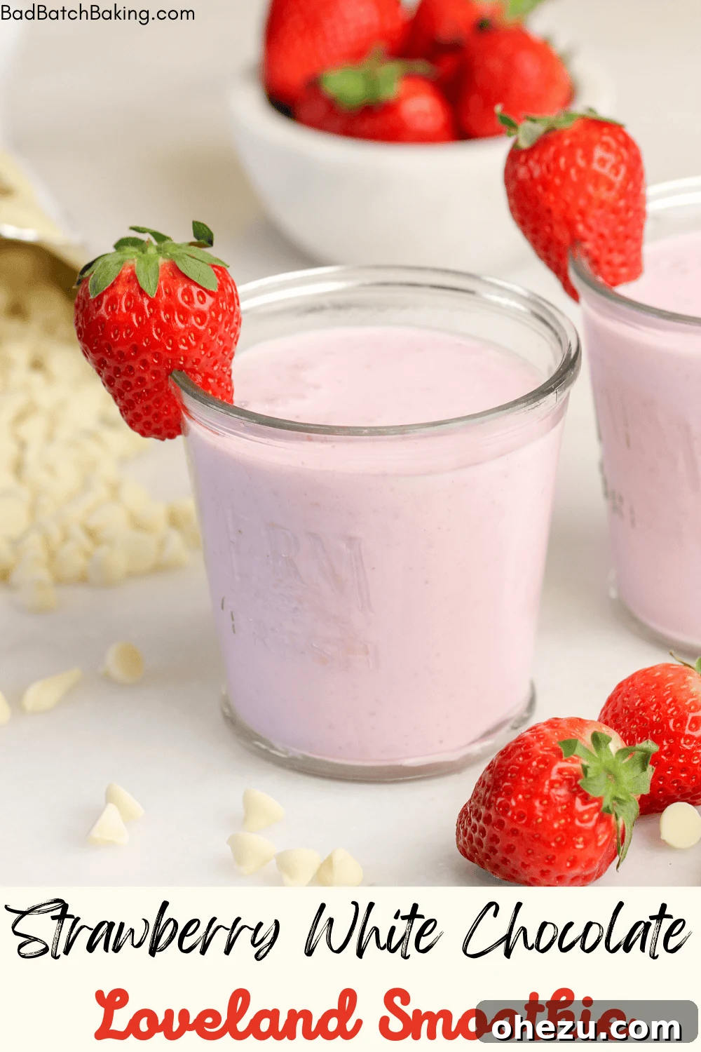 Overhead shot of a tall glass filled with Strawberry White Chocolate Smoothie, on a wooden surface.