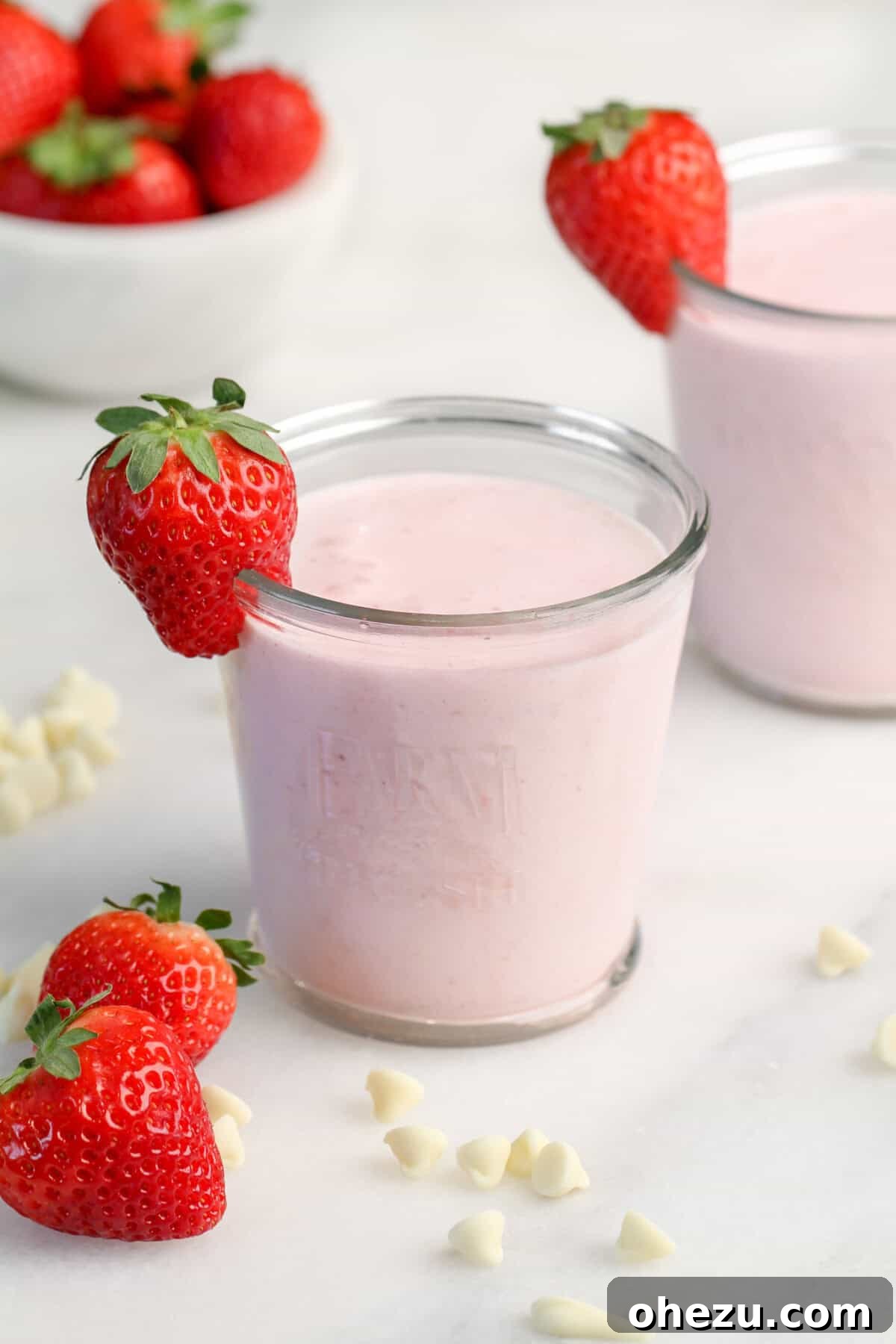 A freshly blended Strawberry White Chocolate Smoothie in a tall glass, with vibrant red color and frothy top.