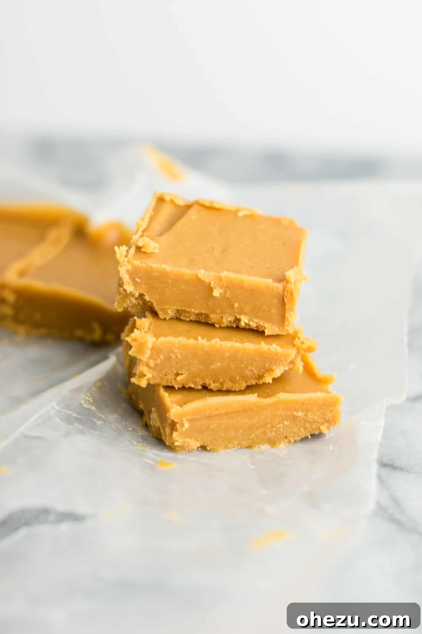 Ultimate healthy vegan peanut butter fudge recipe, showing a stack of fudge squares. #healthyfudge #healthyveganfudge #vegandessert #peanutbutter #glutenfree #vegan