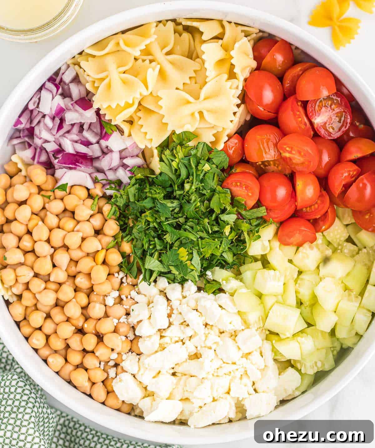 Ingredients for chickpea pasta salad arranged neatly in a mixing bowl before combining