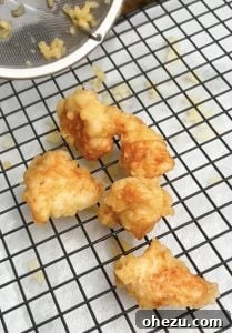 Irresistibly Crispy General Tso's Chicken Recipe 7 Golden crispy fried chicken draining on a rack