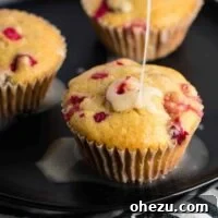 Healthy Cranberry Orange Muffins with Greek yogurt and whole wheat pastry flour, topped with orange glaze.