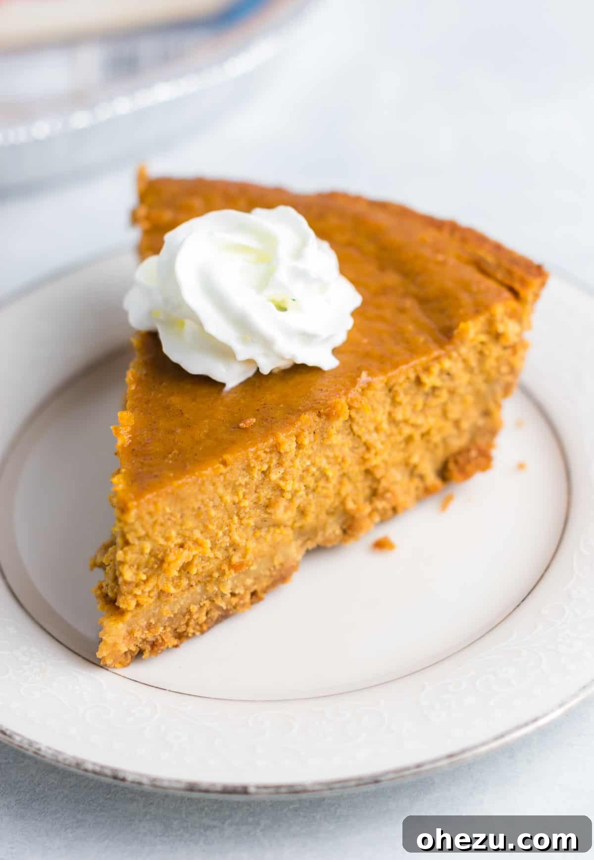 A vibrant gluten-free pumpkin pie, freshly baked with a slight crack on top, showcasing its rich orange color before cooling down.