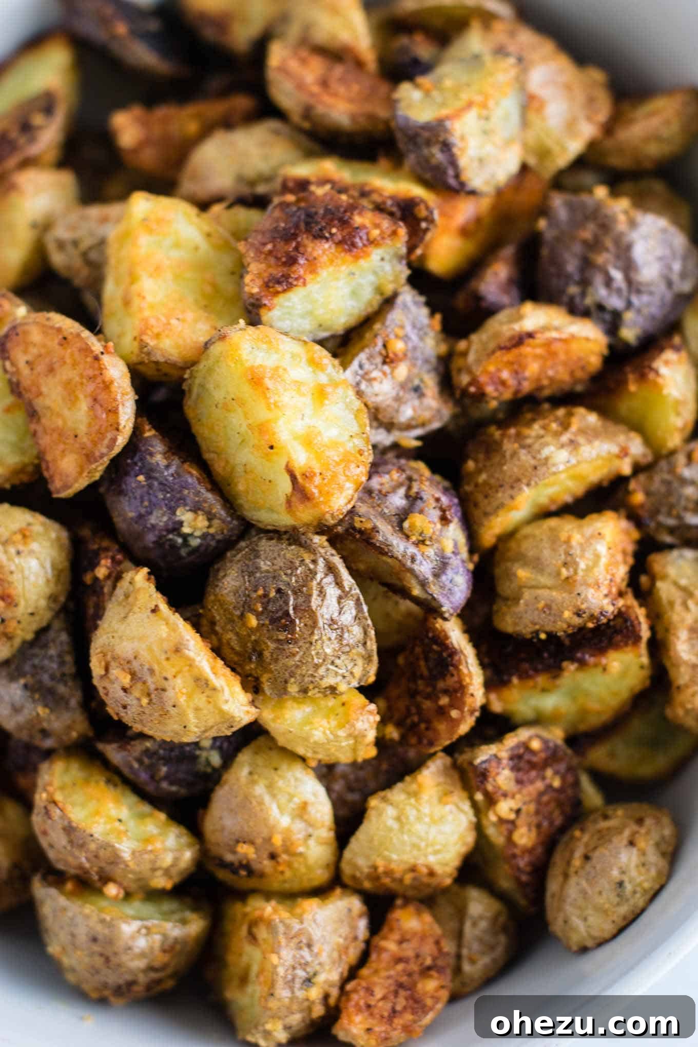 A close-up on the inviting texture of garlic parmesan roasted potatoes, highlighting their golden color and seasoning.