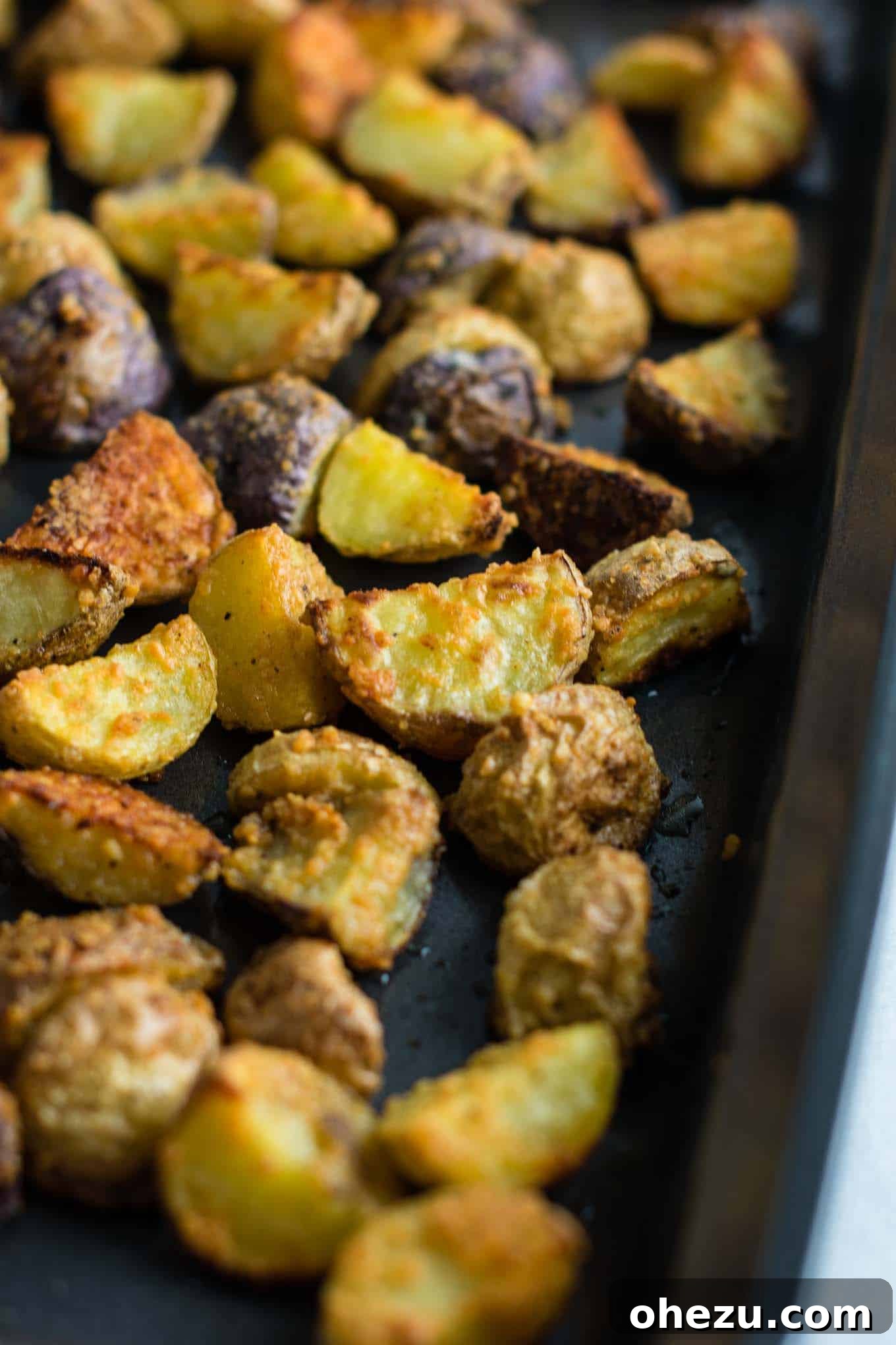 A beautifully composed shot of cooked garlic parmesan roasted potatoes, showcasing their texture and golden-brown finish.