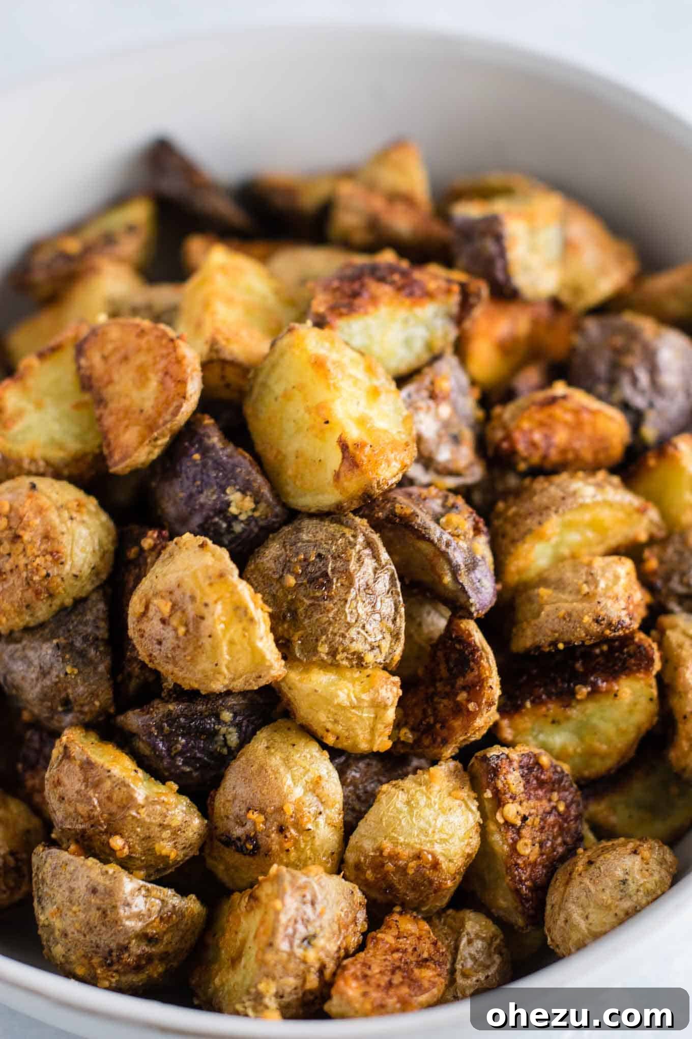 Overhead view of a full pan of irresistible garlic parmesan roasted potatoes, perfectly seasoned and ready to eat.