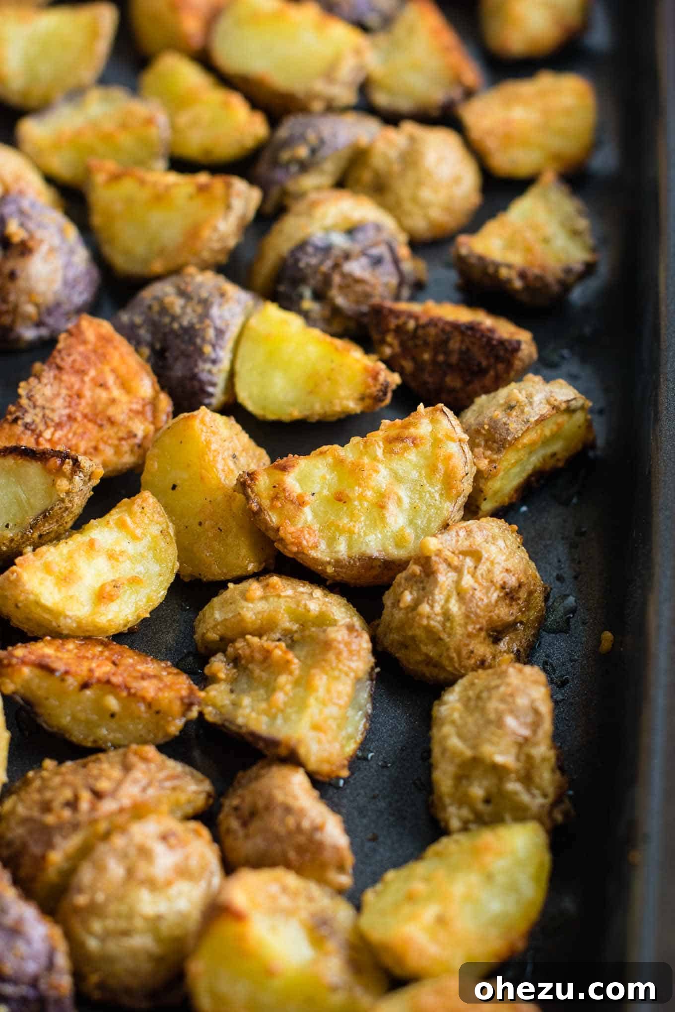 Freshly roasted garlic parmesan potatoes, golden and irresistibly crispy, just out of the oven.