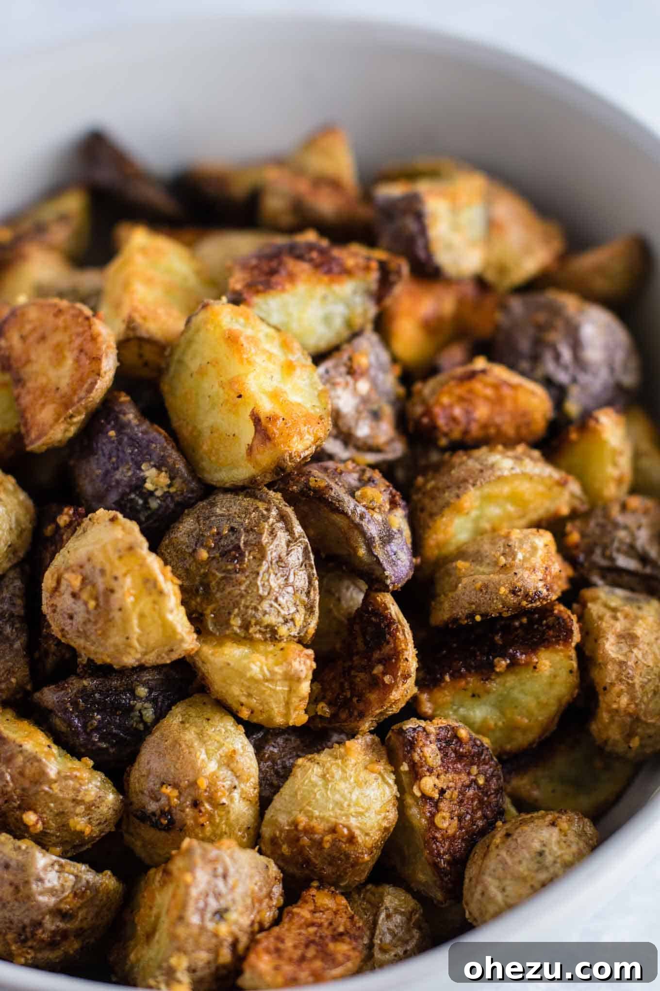 A close-up view of the incredible crispy parmesan crust on roasted potatoes, a truly drool-worthy detail.