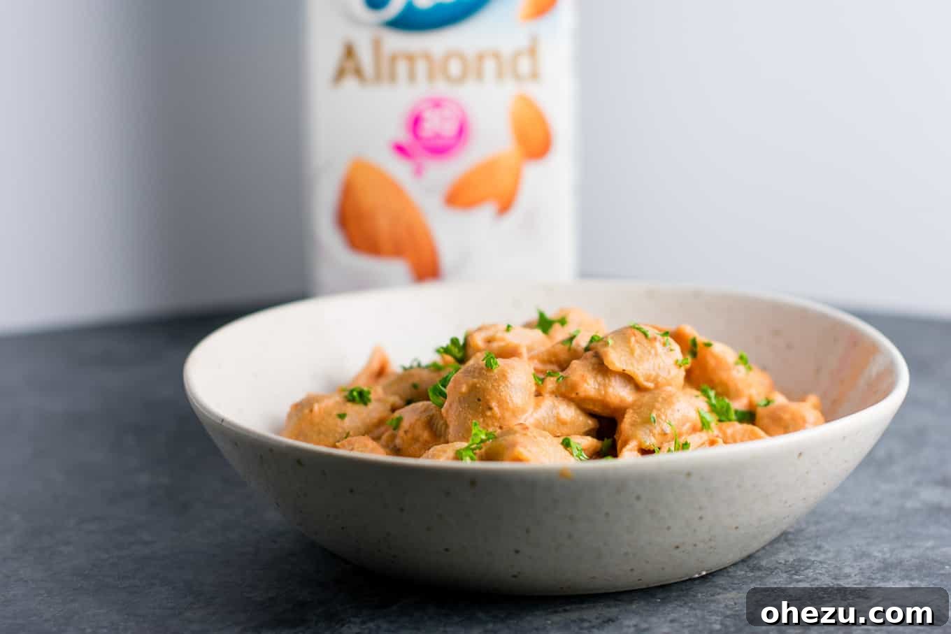 A vibrant close-up of creamy tomato shells, highlighting the rich texture of the vegan rose sauce and whole wheat pasta.