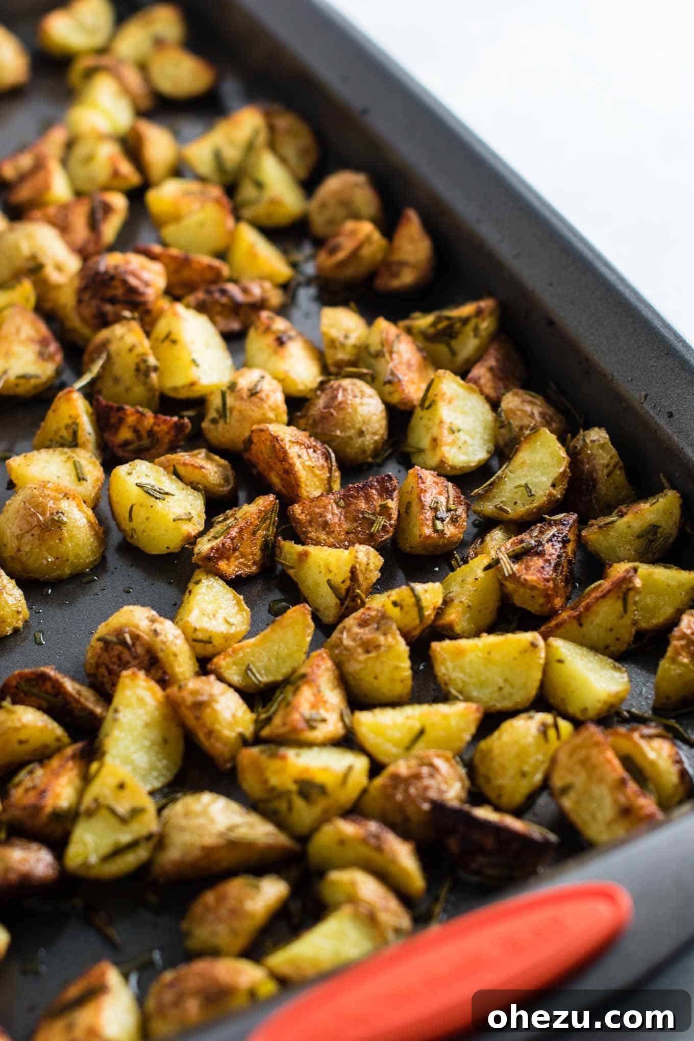 A close-up of the roasted potatoes after the first 15 minutes, slightly golden and ready for a flip.