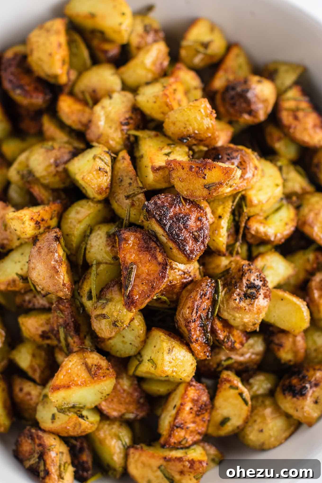 The finished rosemary roasted potatoes, golden and crispy, fresh out of the oven and ready to be served.