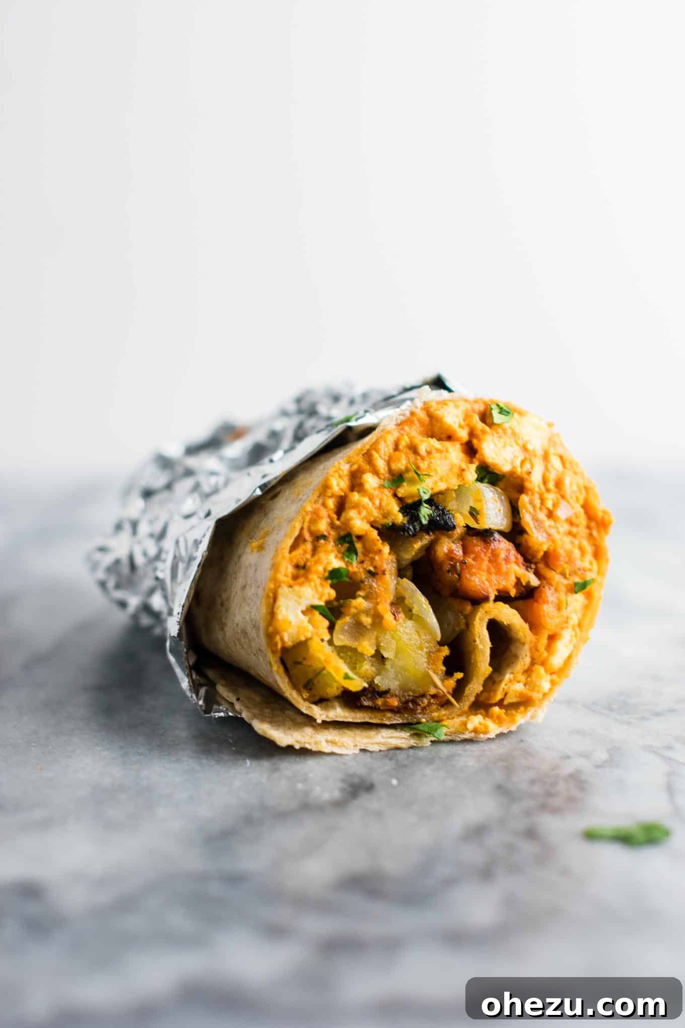 A stack of golden-brown vegan breakfast burritos ready to be eaten