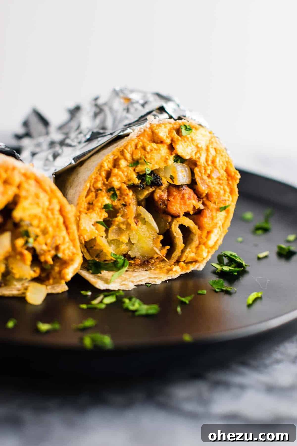 A collection of perfectly wrapped vegan breakfast burritos, ready for meal prep