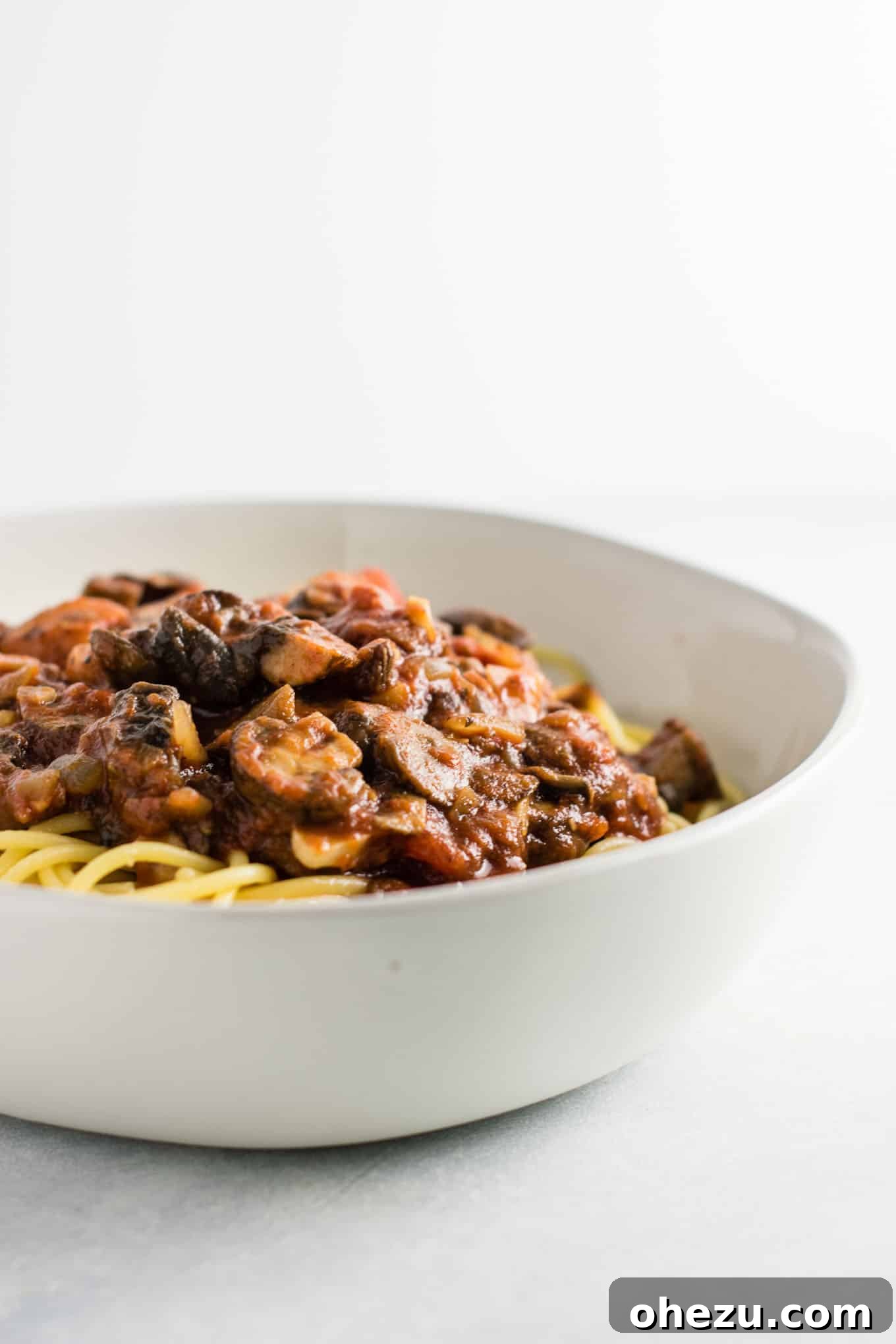 A close-up view revealing the rich, chunky texture of the meatless mushroom pasta sauce, showcasing the finely cooked vegetables.