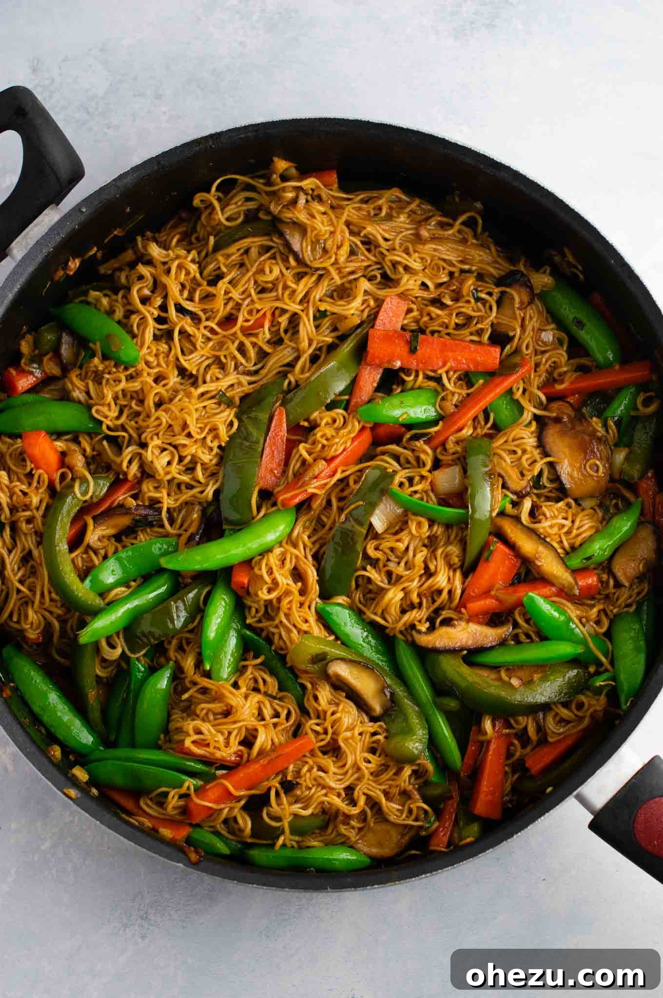 Gourmet Stir Fry Sauce 10 Ramen noodle stir fry with golden oak shiitake mushrooms, sugar snap peas, green bell pepper, carrots, green onions, and fresh garlic and ginger, showcasing a perfectly coated dish.