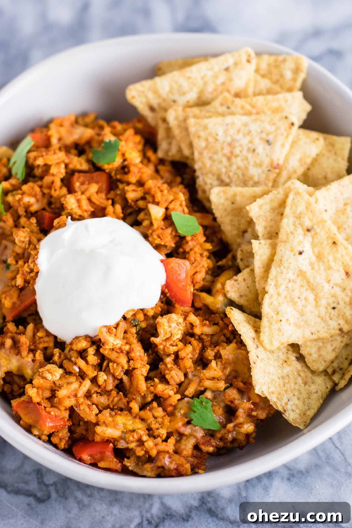 Hearty Tofu Mexican Rice Bake 11 A generous serving of Tofu Mexican Rice Casserole in a bowl, with a fork ready to dig in, emphasizing its hearty and satisfying nature. Perfect for a delicious vegetarian dinner, lunch, or meal prep.