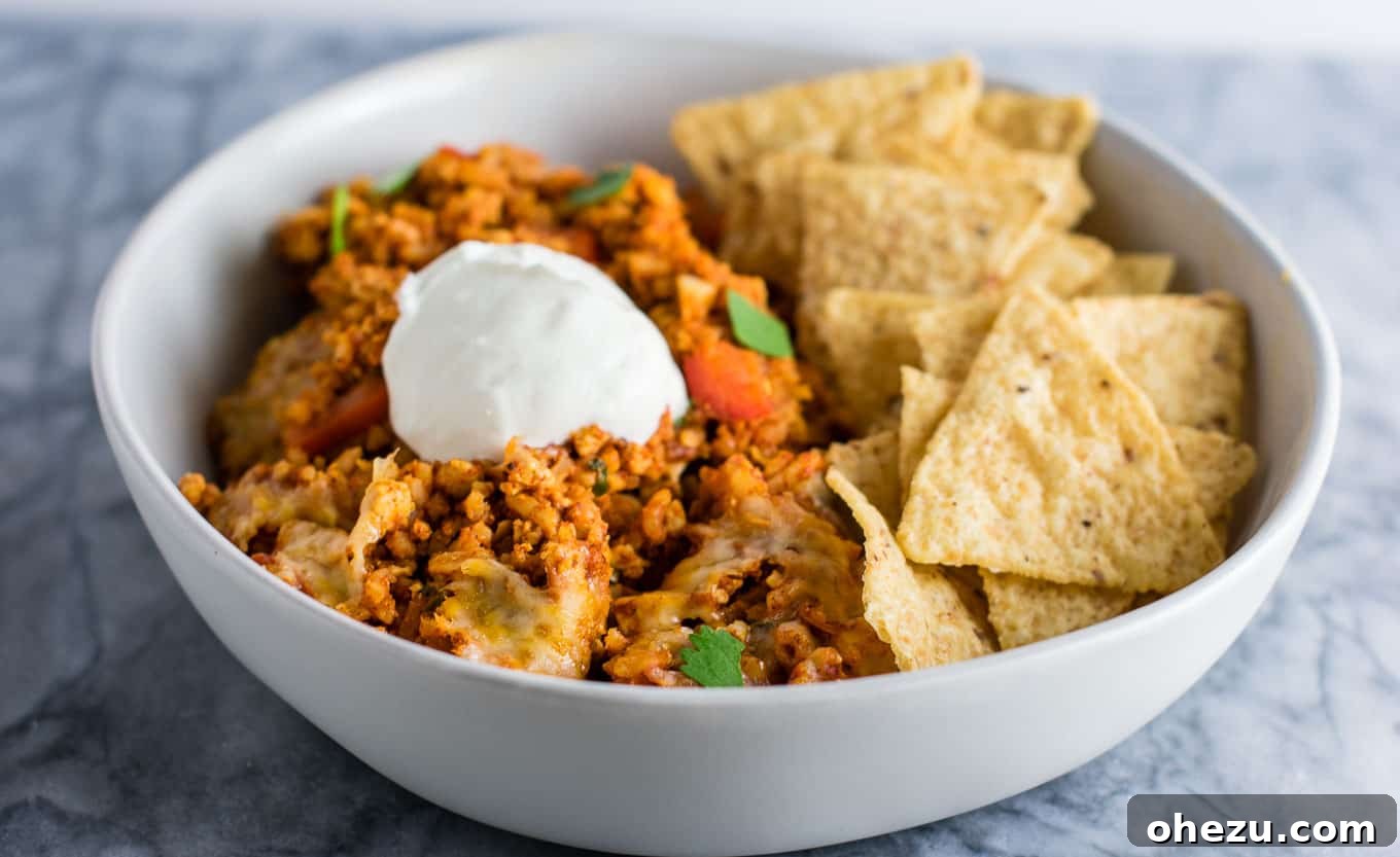 Hearty Tofu Mexican Rice Bake 9 A close-up of the bubbly, golden-brown cheese topping on the freshly baked Tofu Mexican Rice Casserole, indicating it's perfectly cooked and ready to be enjoyed with its irresistible texture.