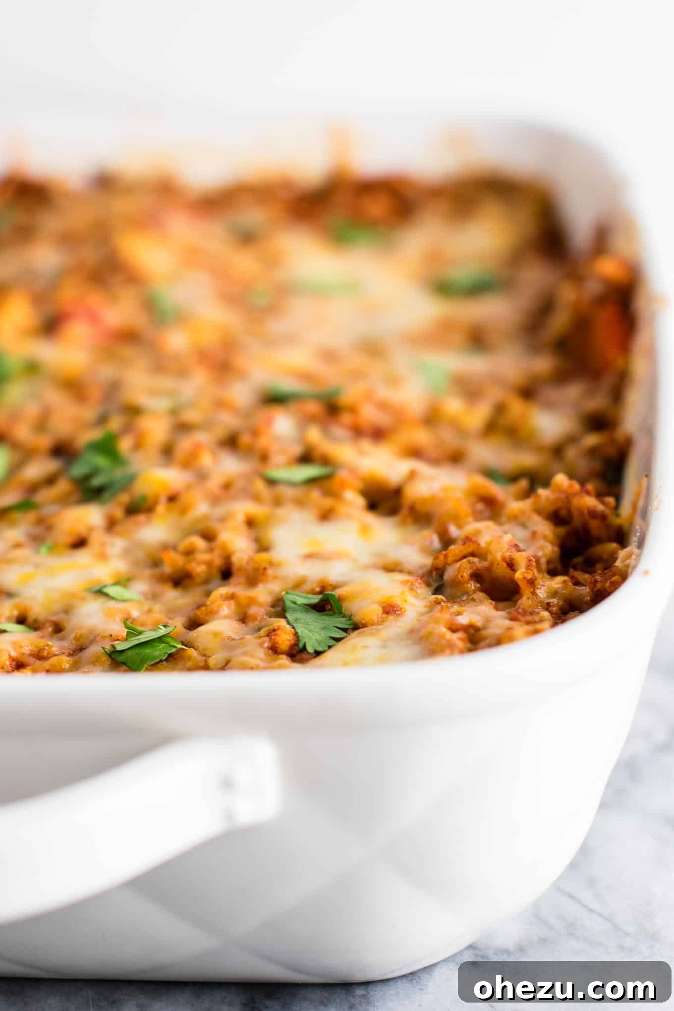Hearty Tofu Mexican Rice Bake 10 Top-down view of the beautifully baked Tofu Mexican Rice Casserole, showcasing its appealing presentation with a garnish of fresh cilantro, ready to be portioned and served.