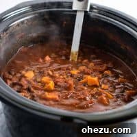 A close-up of a serving of Slow Cooker Vegetarian Sweet Potato Chili, garnished with cilantro.